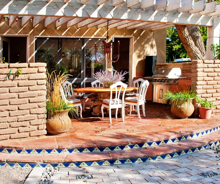 An outdoor patio with a pergola for shade and a heating system for winter